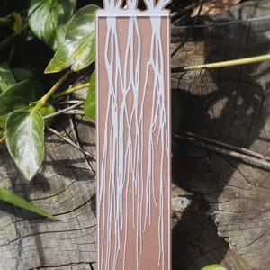 This bookmark has an earthy brown background with delicate white lines resembling intricate fungal root systems or mycelium stretching downward. Mushrooms appear to be growing from the top of the bookmark.