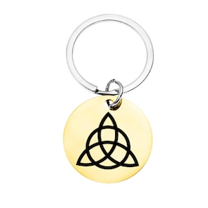 May include: A gold-coloured keychain with a silver key ring. The keychain features a black Celtic knot design.