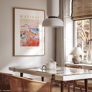 May include: A framed poster with a painting of a colorful landscape with houses and a blue sky. The poster is titled "MATISSE" and has the text "View of Collioure, 1905" and "Henri Matisse, father of art".
