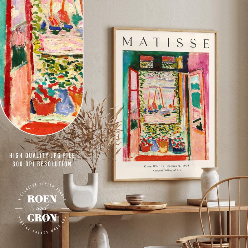 May include: A digital print of a painting by Henri Matisse titled "Open Window, Collioure" depicting a colorful view from a window with boats in the distance. The print is framed in a light wood frame and has the artist's name and the title of the painting printed below the image.