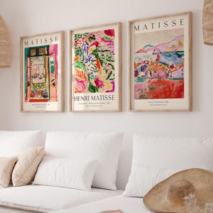 May include: Three framed art prints featuring colorful abstract paintings by Henri Matisse. The prints are titled "Open Window, Collioure 1905", "La Serpentine, Woman Inside the Water 1905", and "View of Collioure 1905".