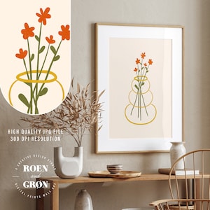 Puede incluir: Una impresi&oacute;n de arte digital de un ramo de flores naranjas en un jarr&oacute;n amarillo. El jarr&oacute;n est&aacute; hecho de tres c&iacute;rculos apilados. La impresi&oacute;n est&aacute; enmarcada y colgada en una pared sobre una mesa de madera.