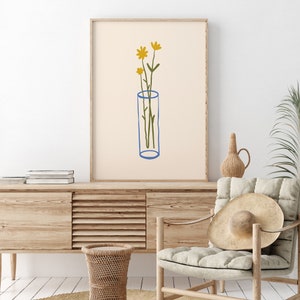 Puede incluir: Una impresi&oacute;n de arte minimalista que presenta un dibujo lineal simple de un jarr&oacute;n con tres flores amarillas. El jarr&oacute;n es azul y el fondo es de color beige claro.