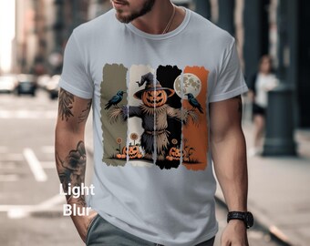 Könnte beinhalten: Hellblaues T-Shirt mit einem Halloween-Motiv. Die Grafik zeigt eine Vogelscheuche mit einem Kürbiskopf, Krähen, Kürbissen und einem Vollmond. Das Design ist vor vertikalen Farbblöcken in Grün, Schwarz und Orange angeordnet.