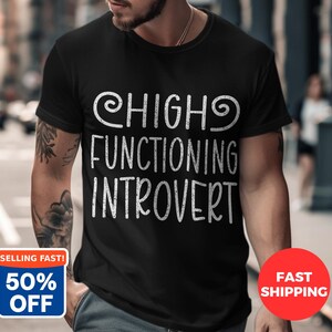 Könnte beinhalten: Eine weiße Keramik-Tasse mit schwarzem Henkel und dem Text "But First, Coffee" in schwarzer, fetter Schrift. Die Tasse steht auf einer weißen Oberfläche.