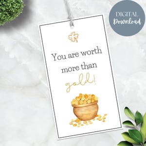 Könnte beinhalten: Ein weißes Geschenkanhänger mit dem Text "You are worth more than gold!" in schwarzer und goldener Schrift. Es zeigt eine Aquarellillustration eines Topfes mit Goldmünzen und einem vierblättrigen Kleeblatt. Das Etikett ist mit einer Schnur gebunden und hat ein "DIGITAL Download"-Etikett.