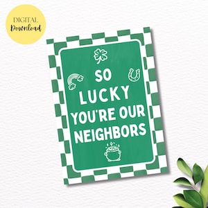 May include: A St. Patrick's Day themed sign with a green background and white text that reads "SO LUCKY YOU'RE OUR NEIGHBORS". The sign includes a shamrock, rainbow, horseshoe, and pot of gold illustrations. A yellow circle with "DIGITAL Download" is in the upper left corner.