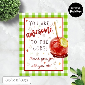 Può includere: Un cartello digitale con bordo rosso e motivo a quadretti verdi. Il cartello presenta un'illustrazione di mela caramellata e il testo "YOU ARE awesome TO THE CORE! Thank you for all you do!". Il cartello misura 21,6 cm x 27,9 cm.