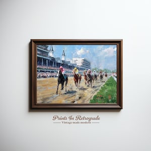 May include: A framed painting depicts a horse race in progress. The artwork features a dark brown wooden frame. The painting shows several horses and jockeys racing on a dirt track, with a crowd of spectators in the background. The sky is blue with clouds.