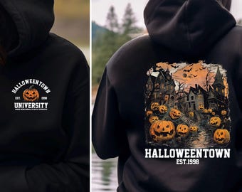 May include: Black hooded sweatshirt with "Halloweentown University" and a pumpkin graphic on the front. The back features a spooky Halloween scene with pumpkins, houses, and the text "Halloweentown Est. 1998".