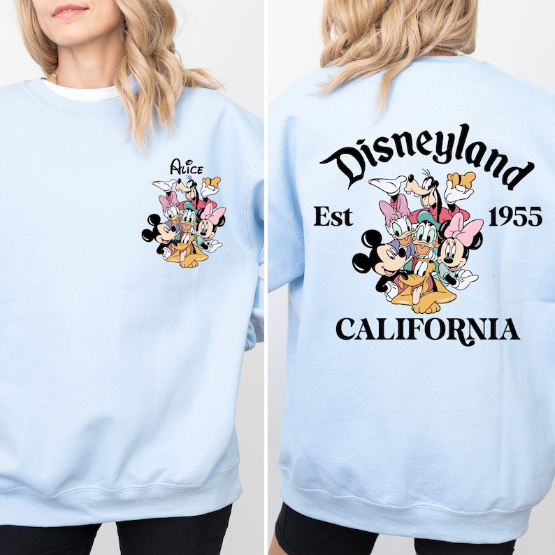 May include: Light blue sweatshirt with a graphic of Mickey Mouse, Minnie Mouse, Donald Duck, Goofy, and Pluto on the front. The back of the sweatshirt has the text 'Disneyland Est 1955 CALIFORNIA'.
