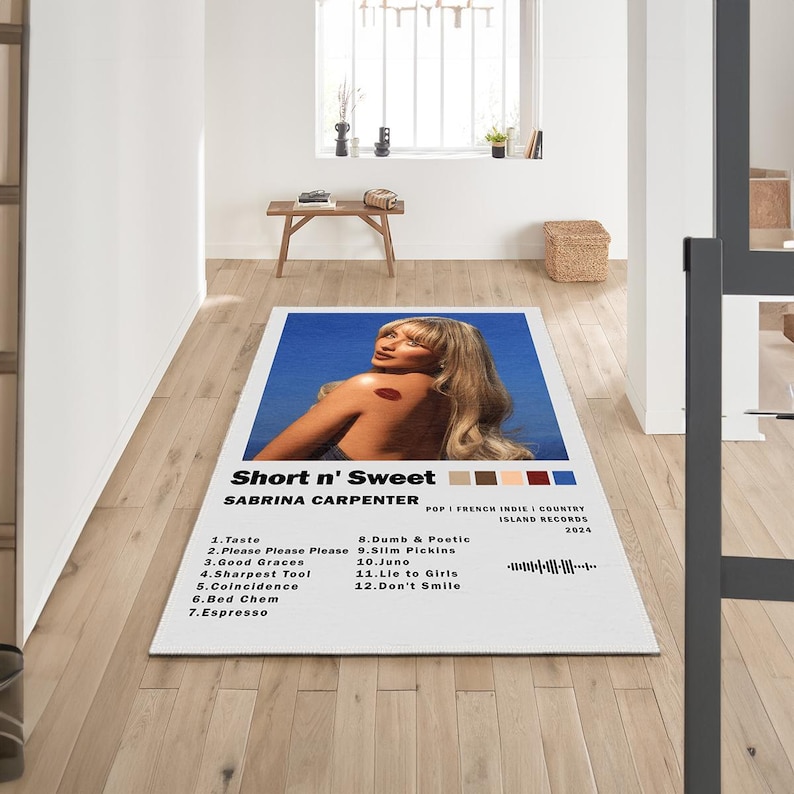 May include: A white album cover with a blue background featuring a woman with blonde hair and a red lip. The album title is "Short n' Sweet" by Sabrina Carpenter. The album cover also includes the album's tracklist.