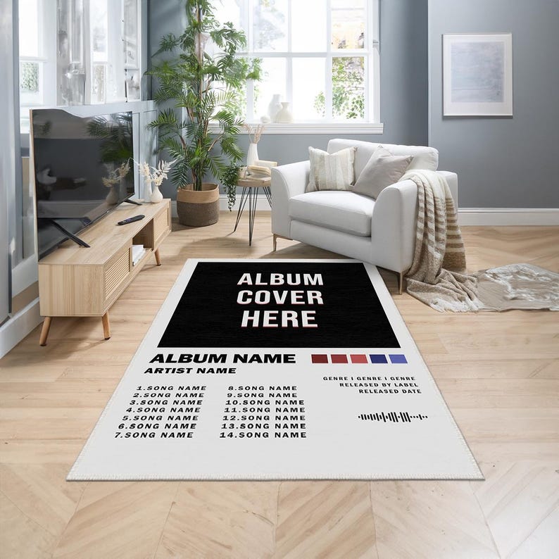 May include: A white rug with a black rectangle in the center that says "ALBUM COVER HERE" in white text. Below the rectangle is a black and white list of song titles and an artist name. The rug is on a wooden floor.