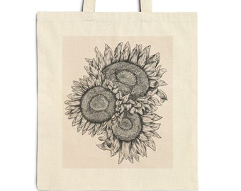 Peut inclure: Un sac fourre-tout beige avec une illustration en noir et blanc de trois tournesols. Les tournesols sont regroupés, avec des traits détaillés définissant les pétales et les centres. Le sac a deux poignées.