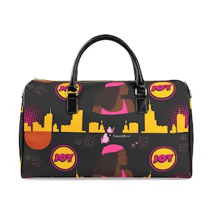 May include: A black duffel bag featuring a repeating graphic pattern of a person with dark hair wearing a pink hat, yellow city skyline silhouettes, pink butterflies, and circular yellow emblems with the word JOY in pink letters.