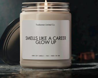Könnte beinhalten: Eine weiße Sojawachskerze mit einem schwarzen Etikett, auf dem "Tradesmen Limited Co. SMELLS LIKE A CAREER GLOW UP 100% SOY CANDLE | 9 OZ | MADE IN USA" steht.