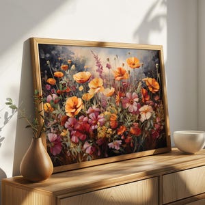 Op de afbeelding: Een ingelijst schilderij van een kleurrijk bloemstuk met oranje, gele, roze en rode bloemen. De bloemen zijn gerangschikt in een veldsetting met groen gebladerte en een wazige achtergrond.