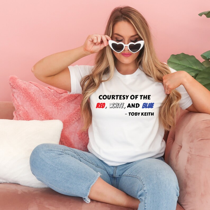 a woman sitting on a couch wearing a t - shirt