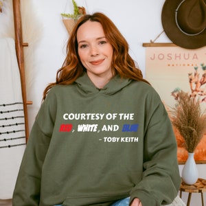 a woman sitting on a chair wearing a green hoodie