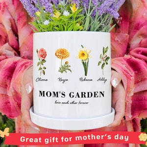 May include: White ceramic planter with a floral design and the text "MOM'S GARDEN love each other forever". The planter has four flowers with the names Cliona, Kayce, Rebecca, and Ashlye written below them.
