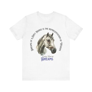 May include: White t-shirt with a circular design featuring a grey horse head and the text "Dreams of a Grey Horse is the Representation of Wisdom" and "Grey Horse Dreams".