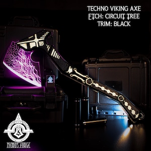 May include: A black and silver techno viking axe with a circuit board design. The axe has a black handle and a silver blade with a circuit board pattern. The axe is illuminated with a purple light. The text "TECHNO VIKING AXE" is displayed above the axe. The text "ETCH: CIRCUIT TREE" is displayed below the axe. The text "TRIM: BLACK" is displayed below the axe. The text "NEMO'S FORGE" is displayed below the axe.