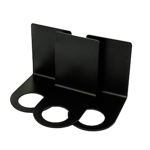 Może przedstawiać: Trzy czarne metalowe podpórki do książek. Każda podpórka ma prostokątny tył i podstawę pod kątem prostym z okrągłym otworem. Podpórki do książek są przeznaczone do utrzymywania książek w pozycji pionowej na półce lub biurku.