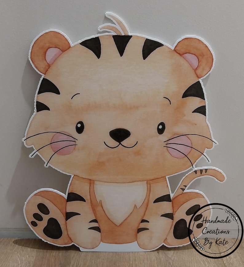 May include: A watercolour illustration of a cute cartoon tiger sitting with its paws in front of it. The tiger is orange and black with pink cheeks and a white belly. The tiger is sitting on a white background.