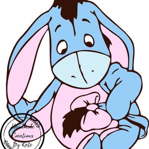 Puede incluir: Un burro de dibujos animados azul y rosa con una expresi&oacute;n triste, sosteniendo un lazo rosa en sus manos. El burro lleva un atuendo rosa y azul. La imagen incluye el texto "Handmade Creations By Kate".