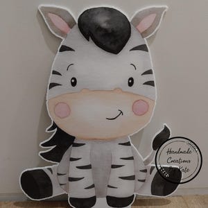 May include: A watercolour illustration of a cute zebra sitting down. The zebra has black and white stripes, a black mane, and pink cheeks. The illustration is on a white background.