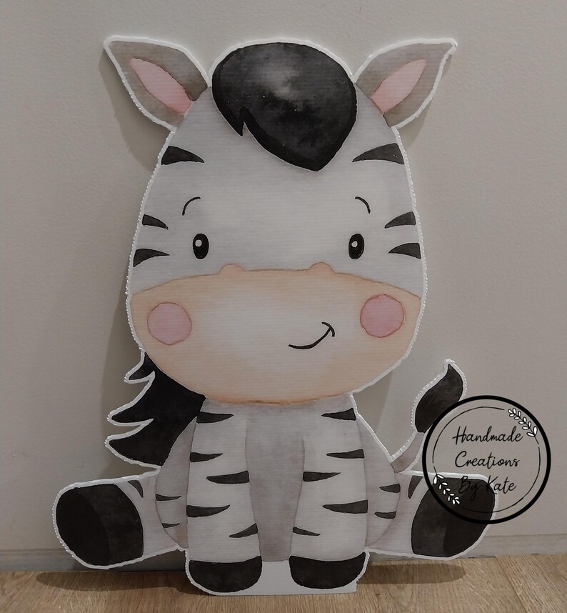 May include: A watercolour illustration of a cute zebra sitting down. The zebra has black and white stripes, a black mane, and pink cheeks. The illustration is on a white background.