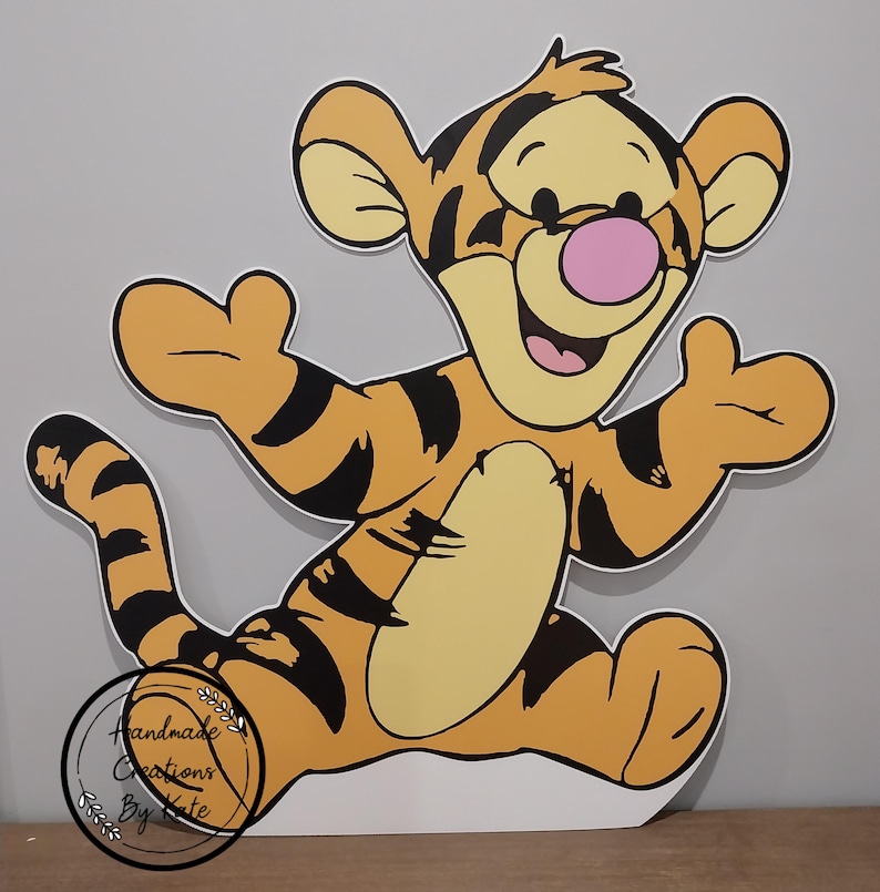 Puede incluir: Un recorte de cart&oacute;n del personaje Tigger de Winnie the Pooh. Tigger es naranja y negro con la barriga amarilla y la nariz rosa. Est&aacute; de pie con los brazos extendidos y las piernas separadas. El recorte est&aacute; hecho de cart&oacute;n y est&aacute; listo para ser usado en una fiesta u otro evento.