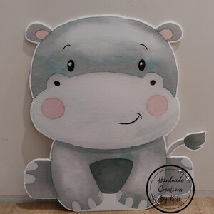 May include: A grey and white watercolour illustration of a hippopotamus with pink cheeks. The hippo is sitting with its legs crossed and has a small tail. The illustration is on a white background and includes the text "Handmade Creations by Kate".