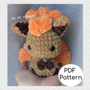 Puede incluir: Un peluche de ganchillo hecho a mano en tonos marrones y naranjas, con ojos de seguridad negros. El juguete tiene un aspecto texturizado y un círculo blanco con el texto "PDF Pattern". El identificador de Instagram "IG: AC_Hinapls" es visible.