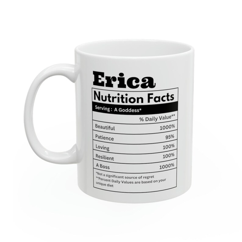 May include: White ceramic mug with the name "Erica" and a "Nutrition Facts" label. The label lists positive attributes like "Beautiful," "Loving," and "A Boss," with corresponding percentage values. The mug has a curved handle.