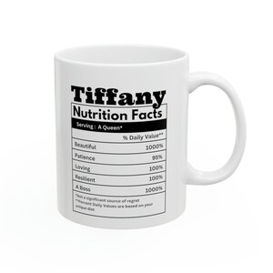 May include: White ceramic mug with the name "Tiffany" and "Nutrition Facts" printed in black. The mug features a nutrition label with values for "Beautiful," "Patience," "Loving," "Resilient," and "A Boss."