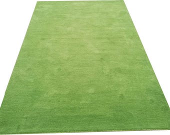 Könnte beinhalten: Ein rechteckiger, einfarbiger grüner Teppich mit einer weichen, strukturierten Oberfläche. Der Teppich hat einen hellen, lebendigen Grünton und scheint aus einem weichen Material zu bestehen. Der Teppich eignet sich für ein Wohn- oder Schlafzimmer.