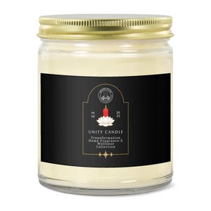 May include: A glass jar candle with a gold lid. The black label features the text "UNITY CANDLE" and a lotus flower with a red candle. The candle is part of the Transformation Home Fragrance & Wellness Collection.