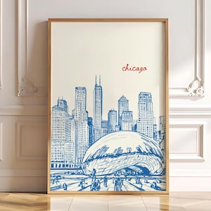 Può includere: Stampa artistica incorniciata con uno schizzo blu e bianco dello skyline di Chicago, inclusa la scultura Cloud Gate. La parola "chicago" è scritta in rosso sopra lo skyline. L'opera d'arte è esposta in una cornice di legno.