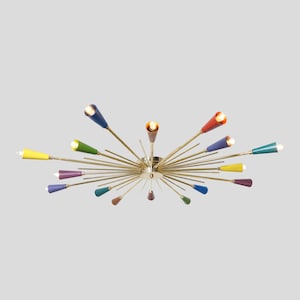May include: A brass ceiling light fixture with multiple arms extending outwards. Each arm has a colourful cone-shaped shade in a variety of colours, including yellow, green, blue, red, and purple.