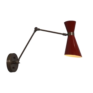 May include: A red and brass wall-mounted light fixture with an adjustable arm. The light has a cone-shaped shade and a vintage design.