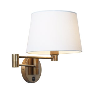 May include: A brass wall-mounted light fixture with a white fabric shade. The light has a swivel arm and a round base with a switch.