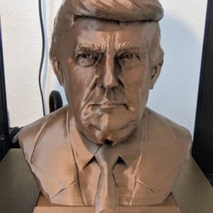 Bronze color Trump Bank. 7 and 1/2 in tall 
6 and 1/2 in in width. 
money slot on the top and a plug that can be taken off on the bottom.