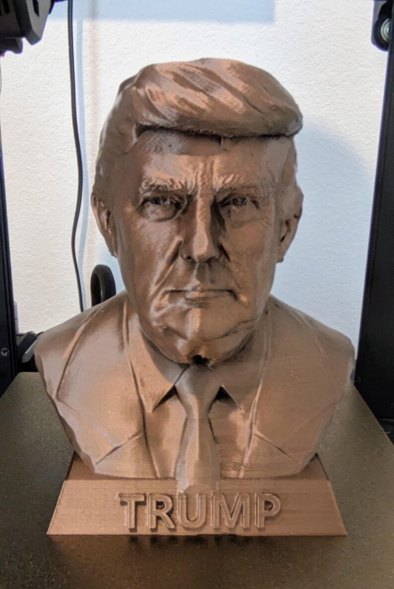 Bronze color Trump Bank. 7 and 1/2 in tall 
6 and 1/2 in in width. 
money slot on the top and a plug that can be taken off on the bottom.