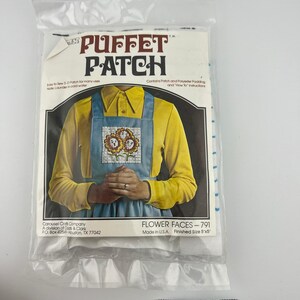 May include: A packaged "Puffet Patch" craft kit featuring a design of flower faces. The kit includes a patch, polyester padding, and instructions. The finished size is 5"x5". The package has text that reads "Easy to Sew 3-D Patch for many uses."