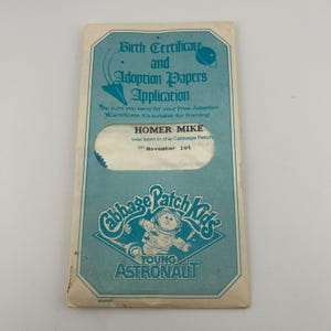 May include: A set of three ceramic mugs with a speckled, matte finish. Each mug features a different color: light blue, cream, and gray. The mugs have a simple, modern design with a rounded shape and a comfortable handle.