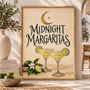 May include: A framed wall art print featuring the text Midnight Margaritas in a dark green script font below a gold crescent moon and star. The illustration depicts two margarita glasses filled with a pale yellow liquid and lime garnishes.