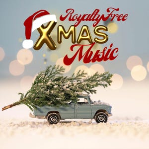 May include: A light blue toy truck carries a Christmas tree through a snowy landscape. The image features the text "Royalty Free XMAS Music" with a Santa hat on the "X". The background has blurred bokeh lights.