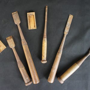 以下が含まれることがあります： 木製の柄と刃を持つ木製のノミが6本、中には木製のケースに入っているものもあります。ノミはサイズと形が異なります。