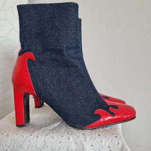 Può includere: Stivali da caviglia rossi e blu con tomaia in denim e un design a fiamma rossa sulla punta. Gli stivali hanno un tacco alto.